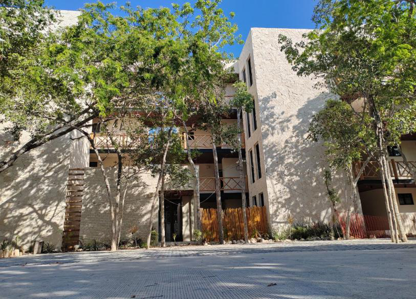 Edificio de Condominios Almare entre árboles en Tulum